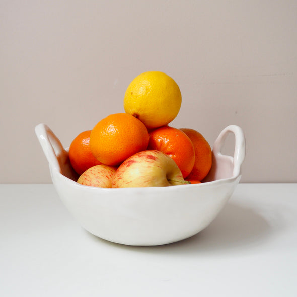 white ceramic bowl with handles and fruit