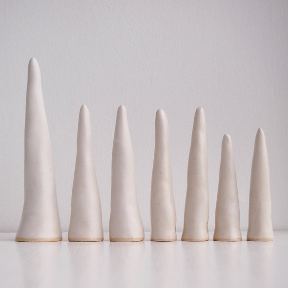 Row of Satin white pottery ring cones