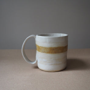 Ceramic mug in stripes of white cream and mustard glaze