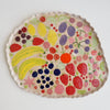 Handmade ceramic platter with fruits and vegetables & curvy top edge.