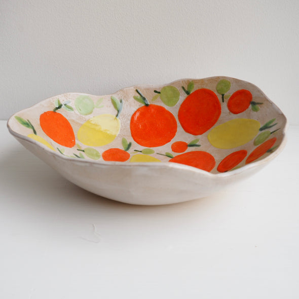 Handmade ceramic fruit bowl with oranges , lemons and limes