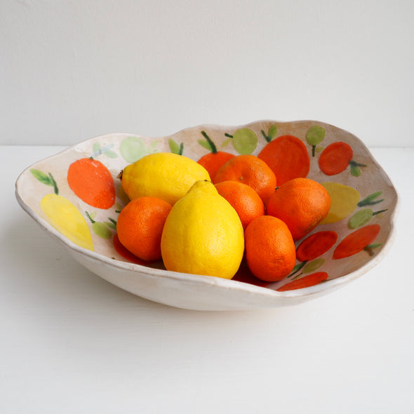 Handmade ceramic fruit bowl with oranges , lemons and limes