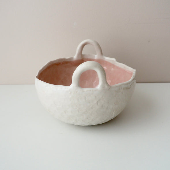 pink and white ceramic bowl with handles