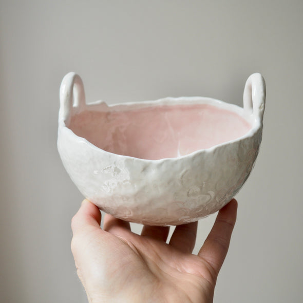 pink and white ceramic bowl with handles