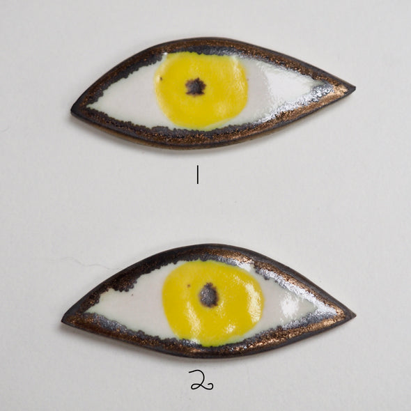 2 yellow eye pin badges