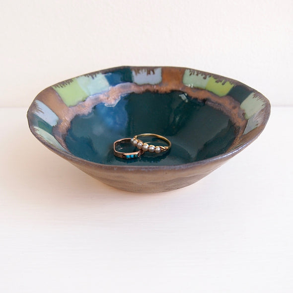 Teal ceramic ring dish with squares and gold detail.