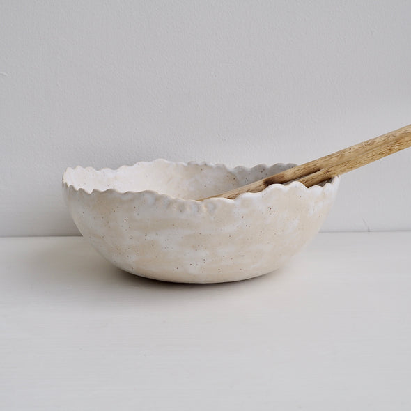 Handmade cream/white speckled scalloped ceramic serving bowl.