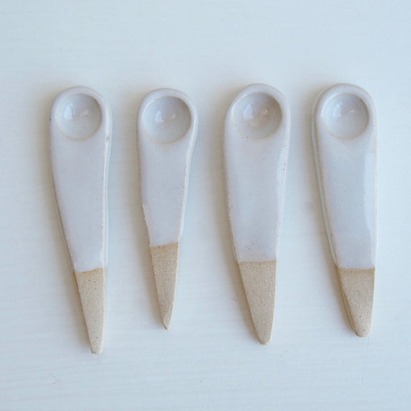 four white pottery salt spoons