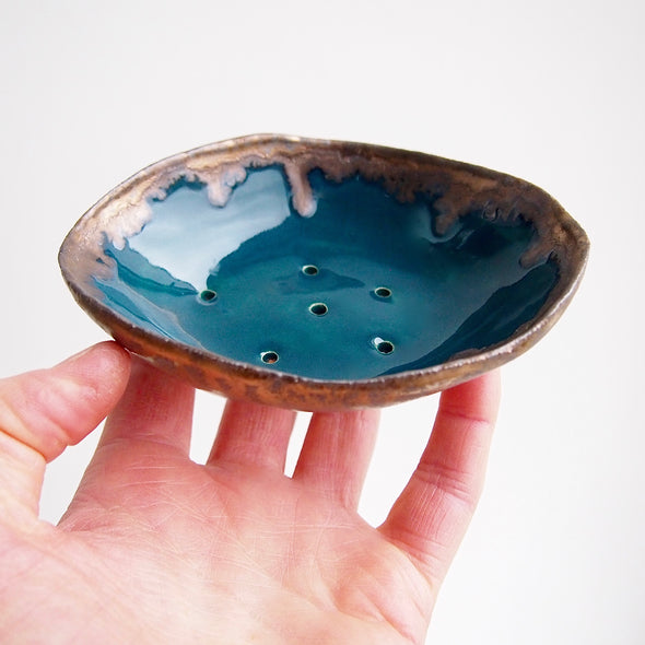 teal and gold ceramic oval soap dish in hand