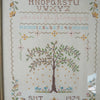 Vintage embroidery sampler with alphabet and tree in frame